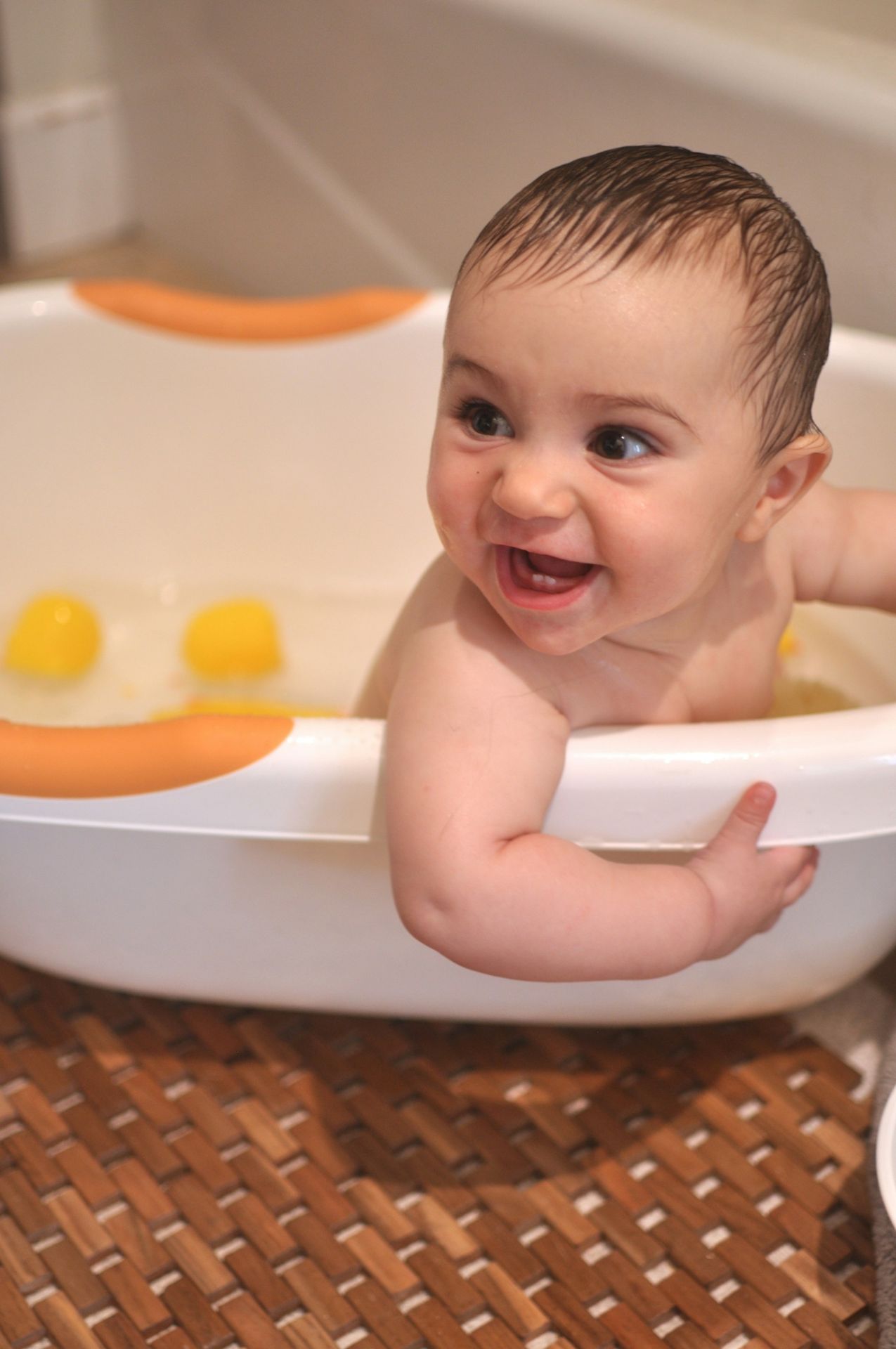 baby in white bathtub with yellow liquid